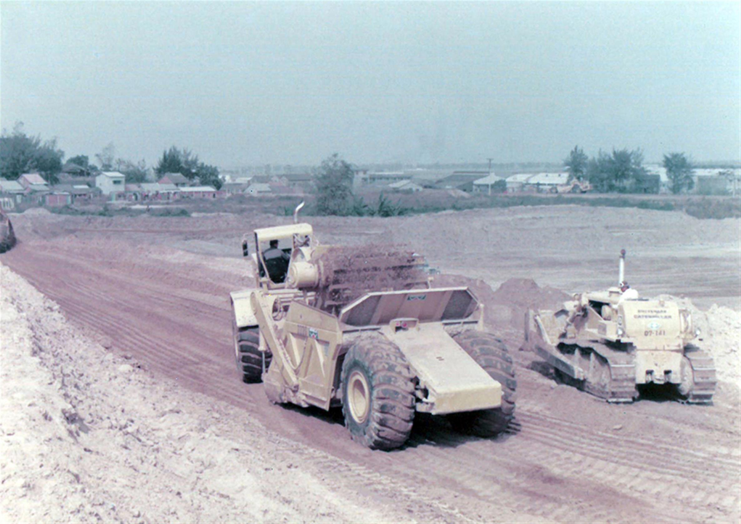 64年括土作業照片左是運土機右為履帶式推土機